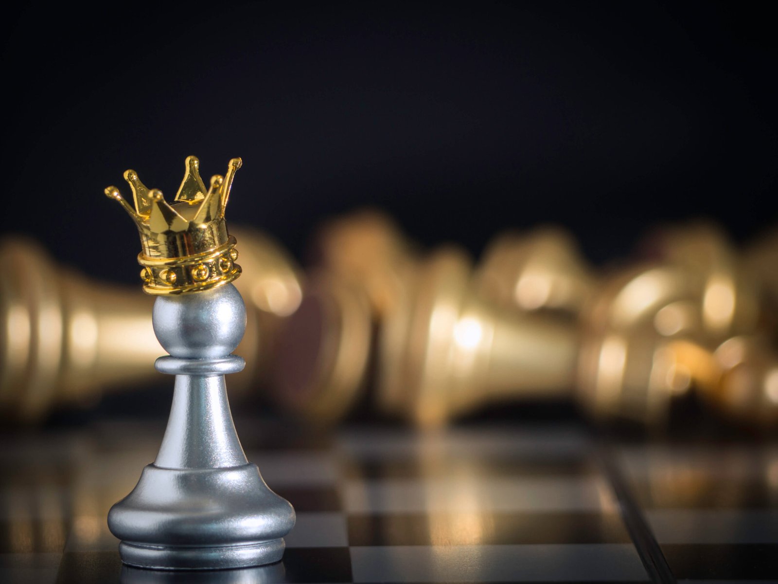 This wallpaper represents a silver pawn with golden crown standing on the chessboard.